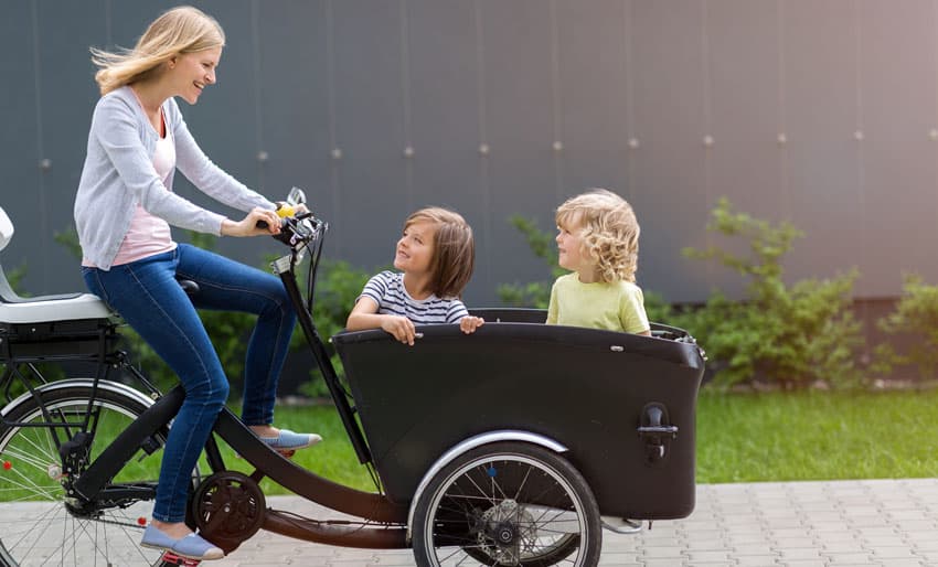 Woman riding an Cargo Ebike with kids